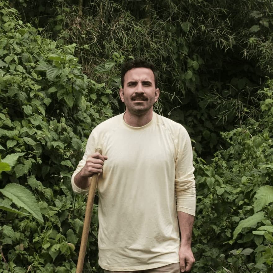 Portrait of Juan Carlos Coppel standing in a green forest