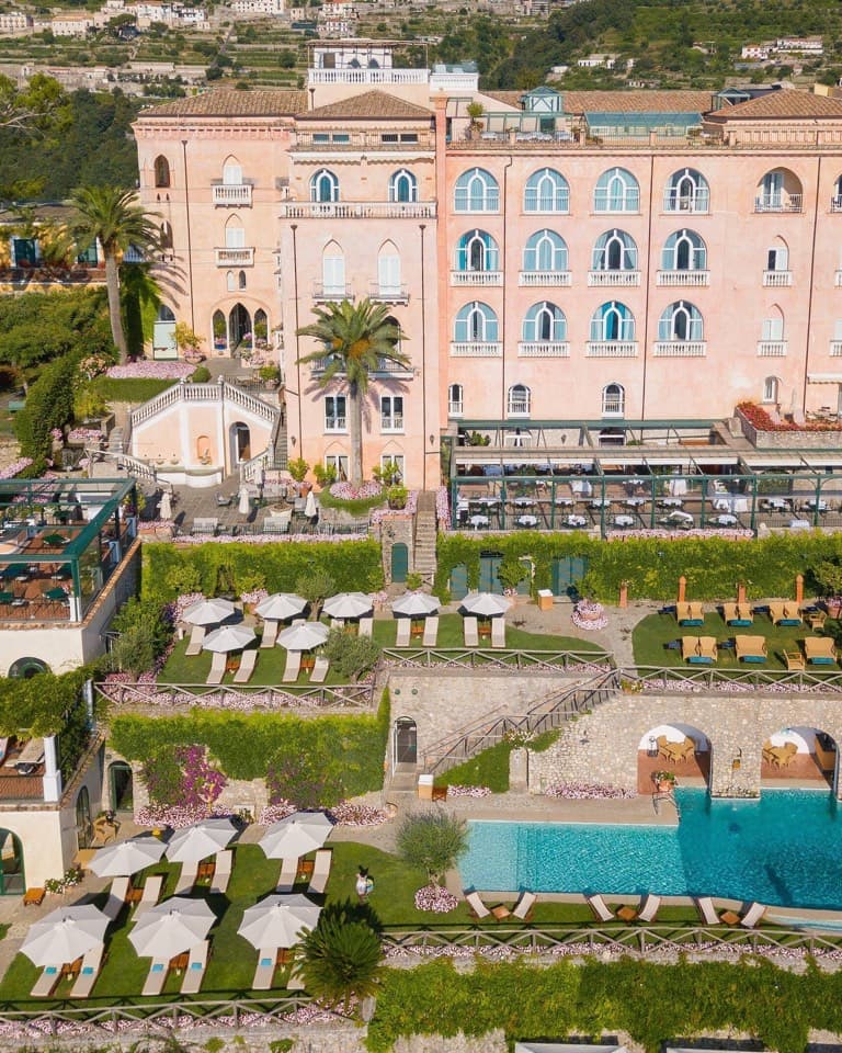 A pink palace with arched windows among gardens